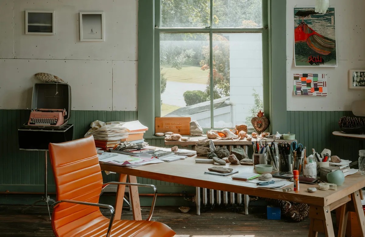 Helles Kreativstudio mit Schreibtisch und Designmaterialien als Referenzbild fuer Cobalt Studio